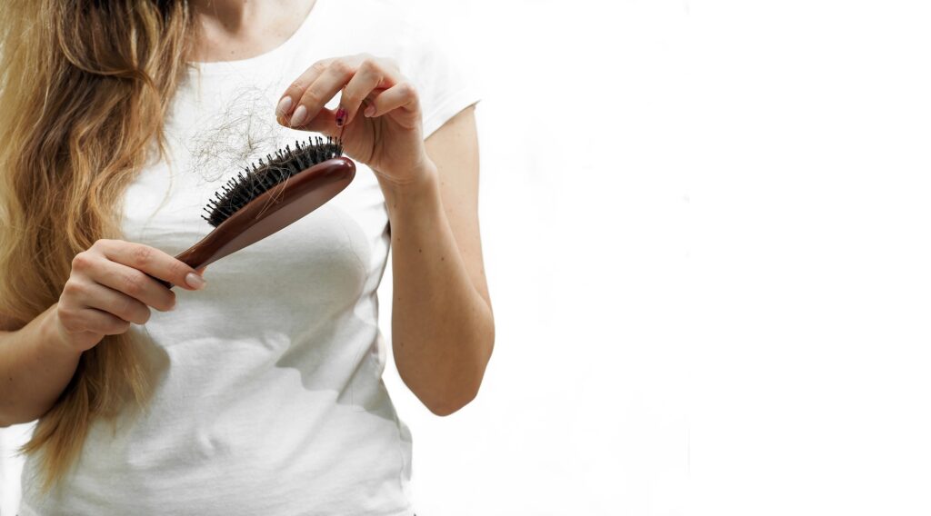 The problem of hair loss in women. Long and thick hair stays on the comb. Banner with space for text